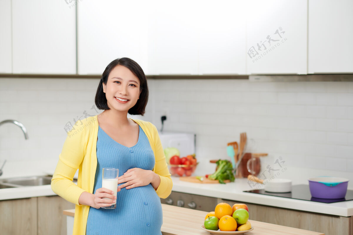 厨房孕妇在厨房喝牛奶母亲期望女人