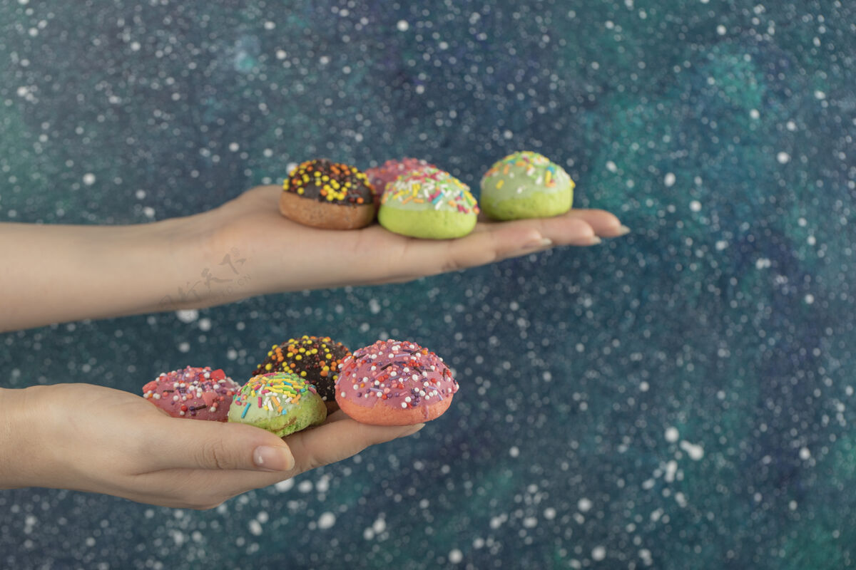 面团手上拿着五颜六色的甜甜的小甜甜圈圆形糖果品种