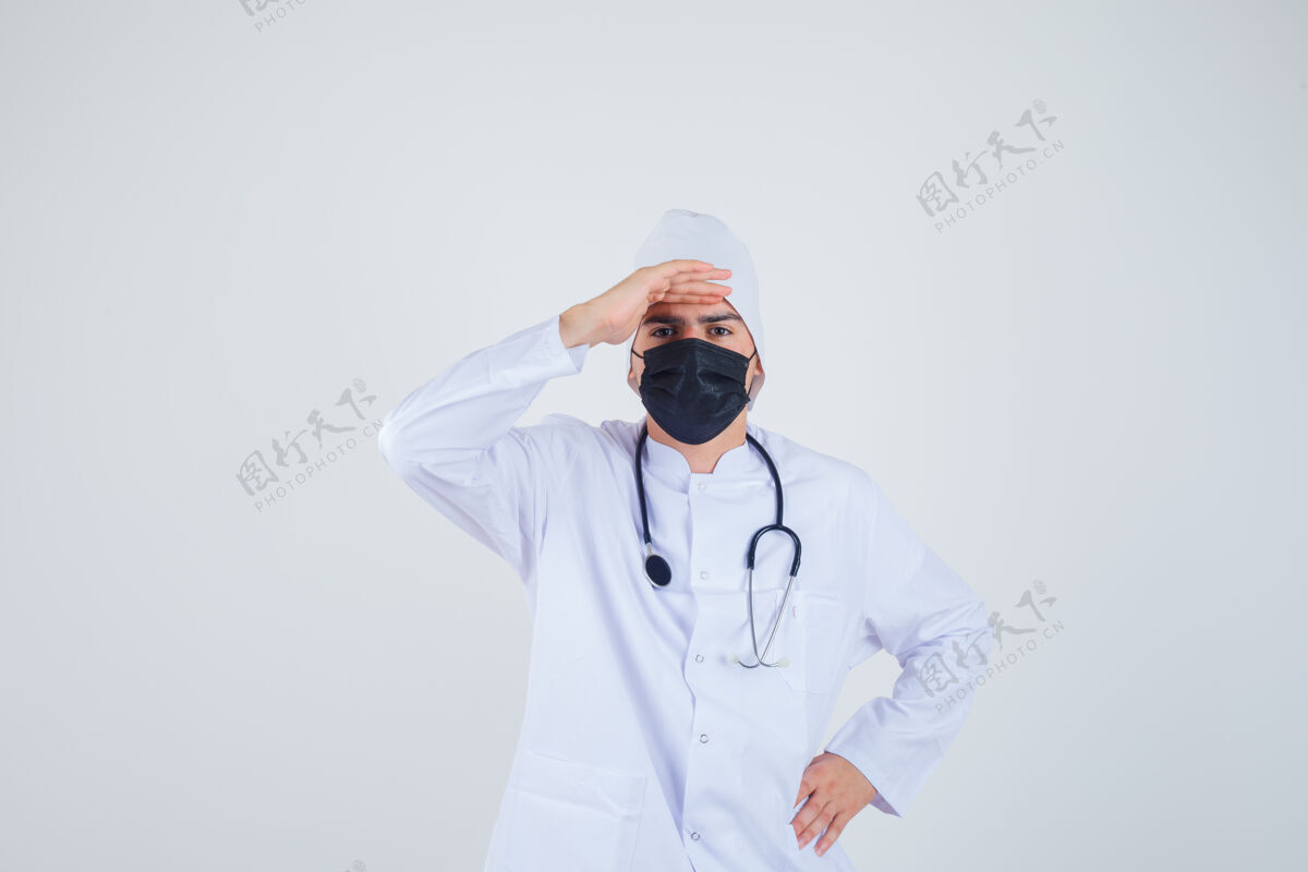 头年轻人头戴白制服 戴着面罩 神色专注地看着远处前视图药专业病人