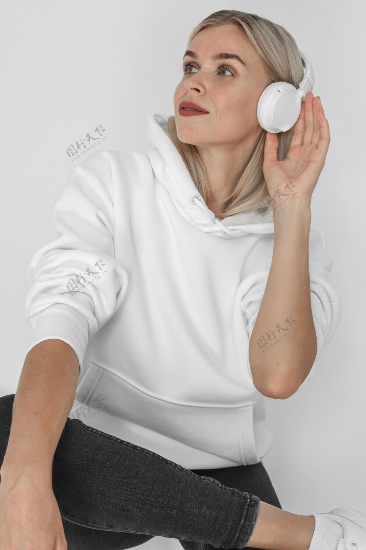 肖像戴着耳机的时尚女士连帽衫的前视图衣服模型服装