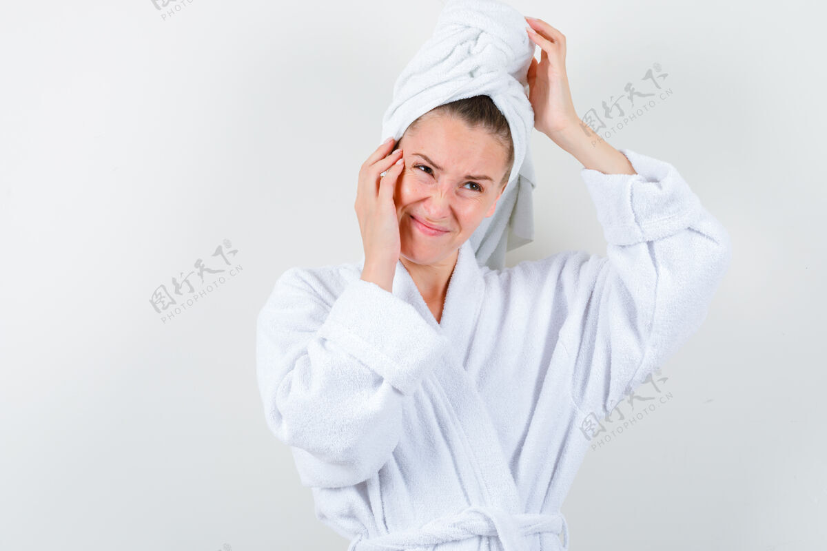 黑发穿着白色浴袍的年轻女士 手捧毛巾 头和脸颊 神情焦躁不安 前视成人毛巾自然