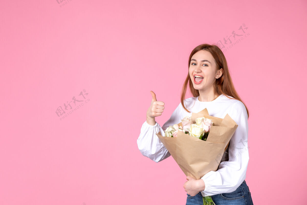 玫瑰正面图：年轻女性 带花朵 作为女性节礼物 粉色背景 水平女性三月性感日期平等玫瑰爱情花花束人