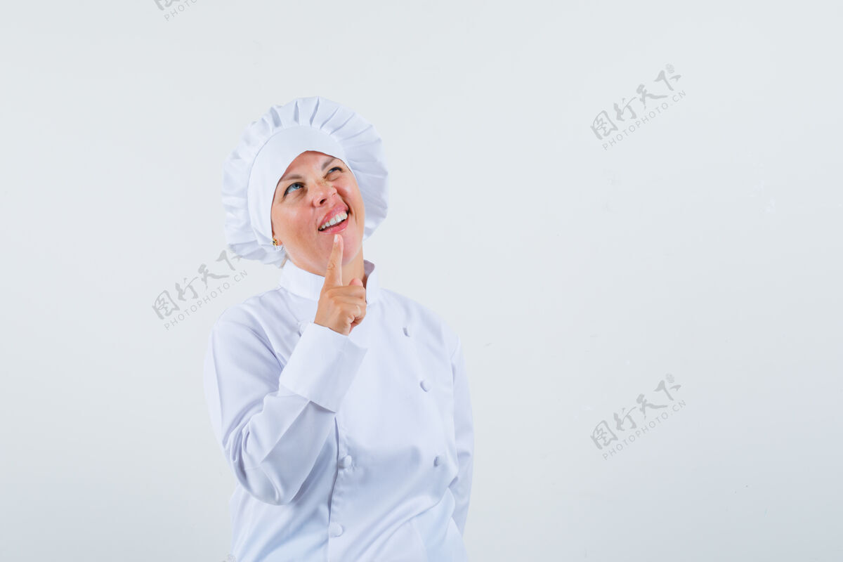 时尚身着白色制服的女厨师展示了一分钟的手势 并期待沉思的文字空间化妆制服粉色