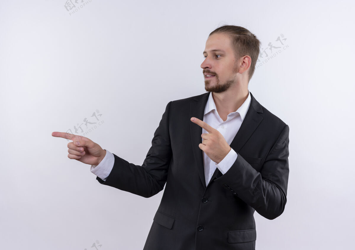 男士穿着西装的帅哥手指着侧面站在白色背景下显得自信侧身看手指