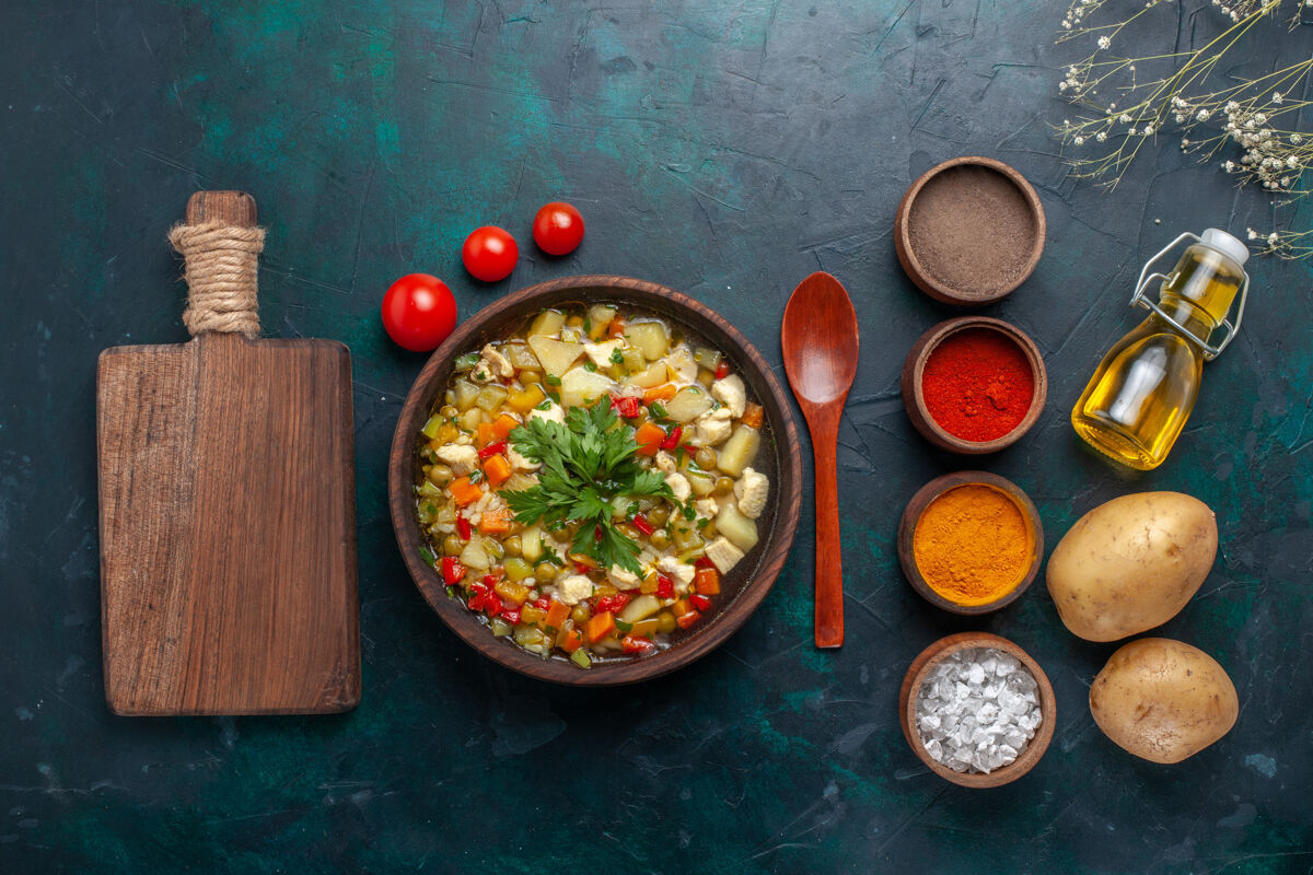 菜俯瞰美味的蔬菜汤与橄榄油和不同的调味品对深蓝色的背景成分蔬菜汤色拉油肉汤油