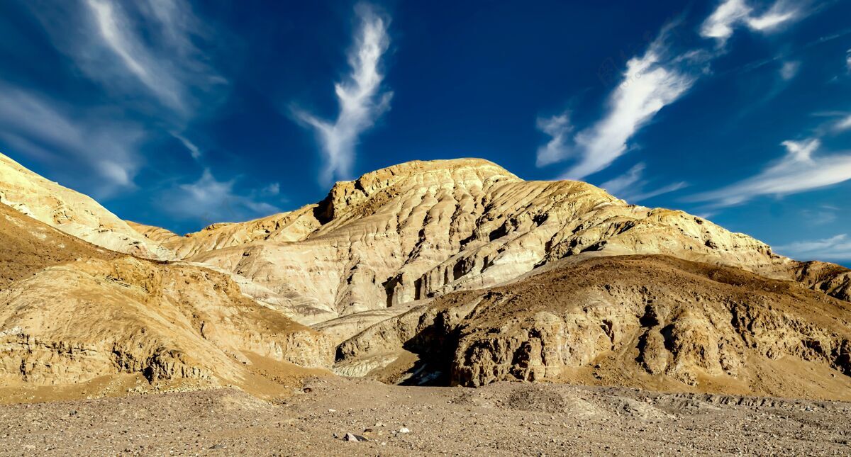 美国在多云的蓝天下 美国加利福尼亚州死亡谷一个岩层的低角度拍摄阳光日岩石形成形成