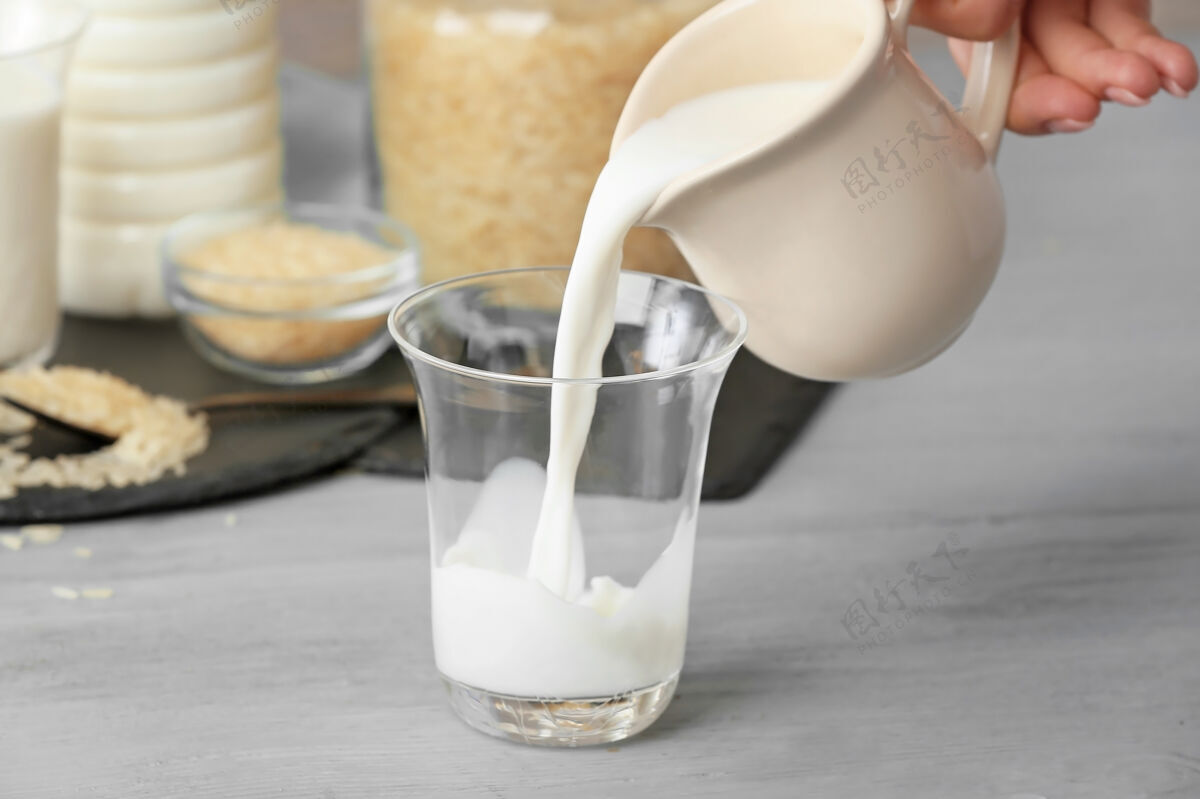 牛奶把牛奶从罐子里倒进桌上的玻璃杯里食物倒的健康