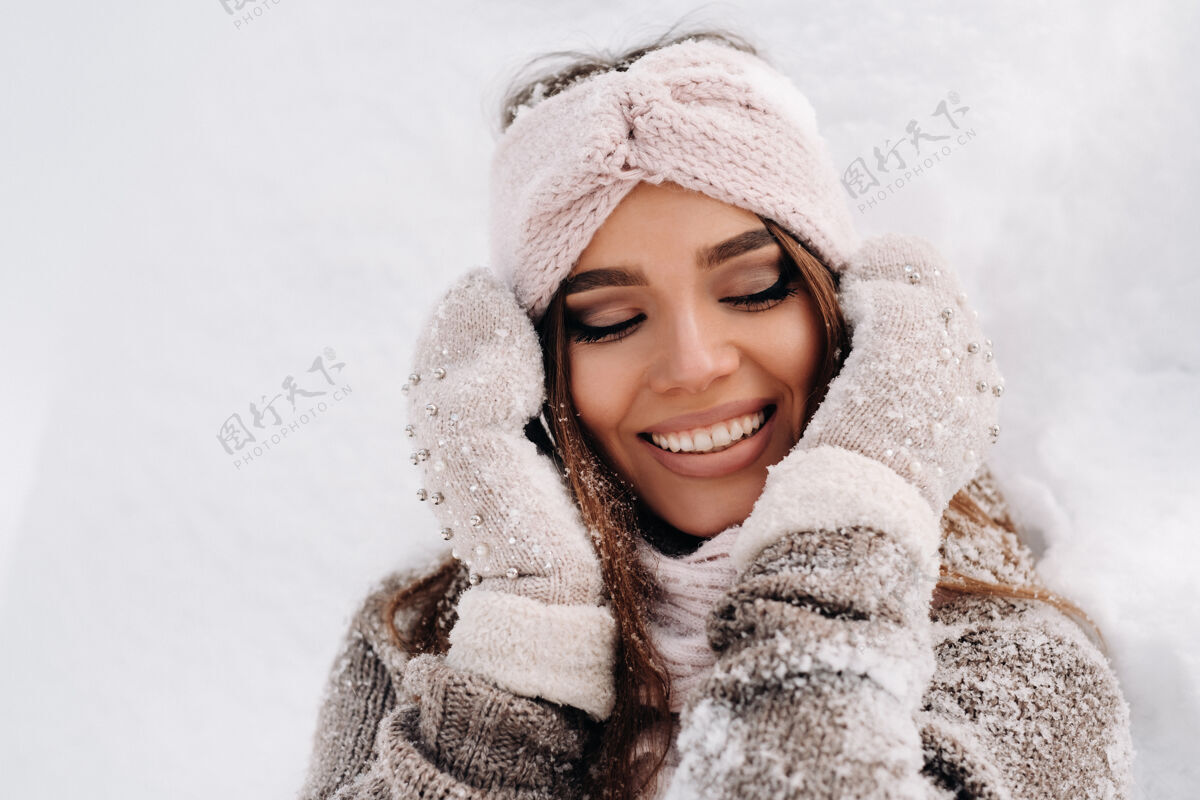 头发冬天 一个穿着毛衣和手套的女孩站在被雪覆盖的背景上自然模特肖像