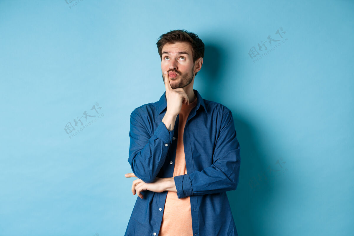 人体贴帅哥做计划 抬头沉思 想象事物 站在蓝色的背景上肖像帅气时尚
