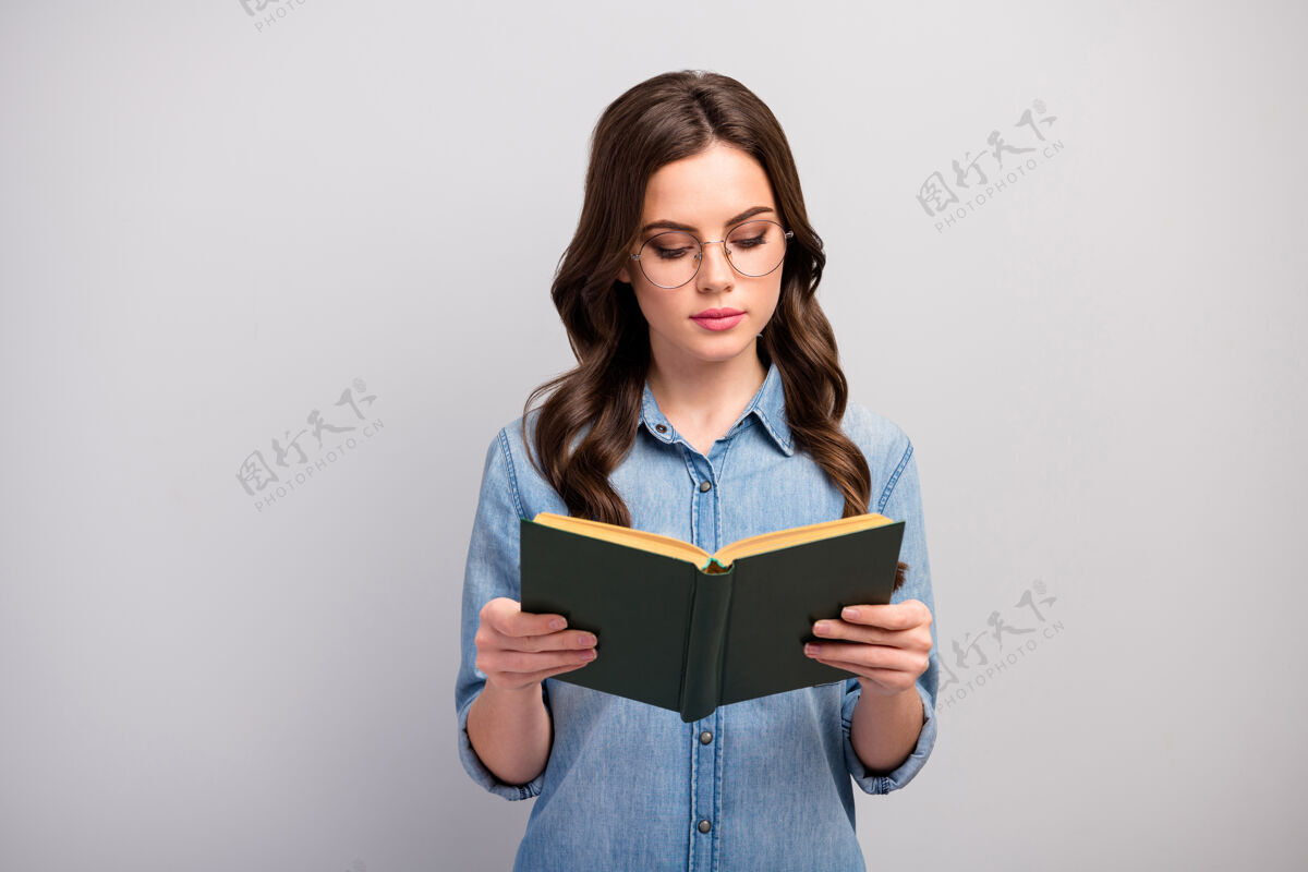 牛仔裤照片相当集中的商务女士拿着书上瘾的读者书蠕虫不微笑穿眼镜休闲牛仔裤牛仔衬衫孤立的灰色眼镜黑发Swoosh