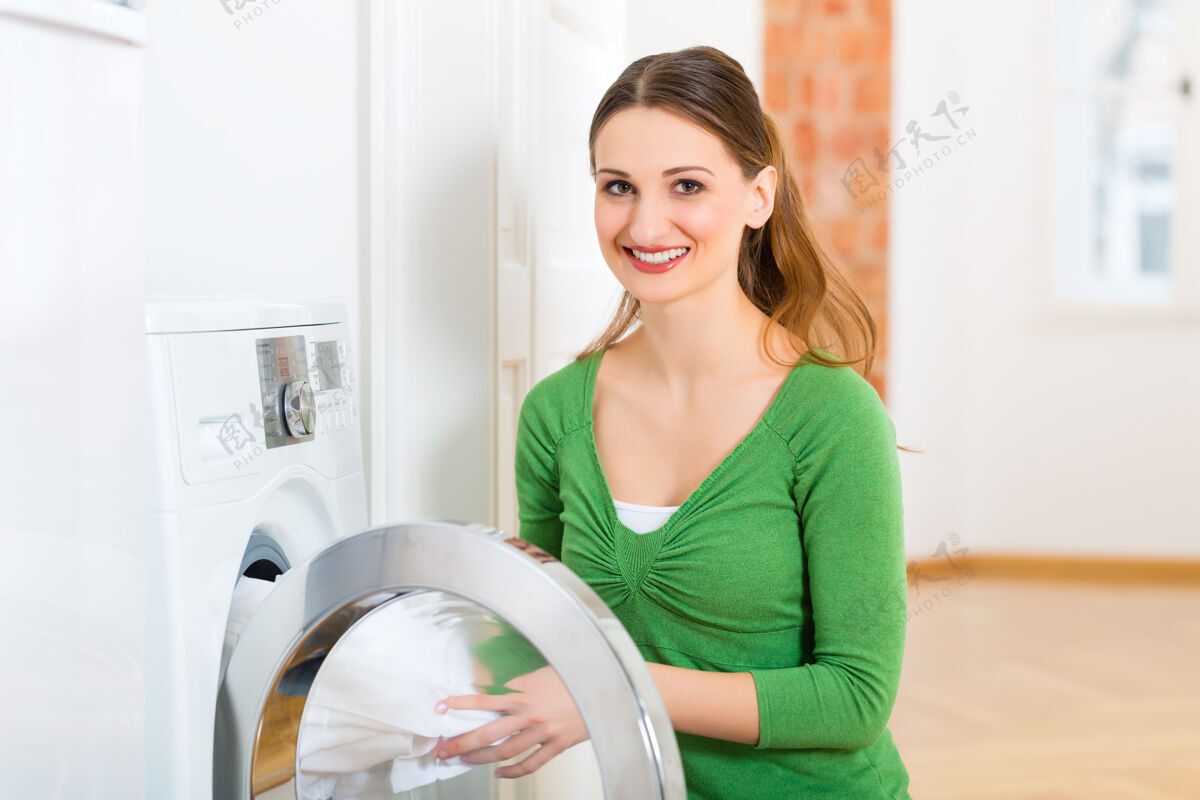 清洁年轻女子或管家有洗衣日在家 她拿出洗衣机或烘干机家务电器工作