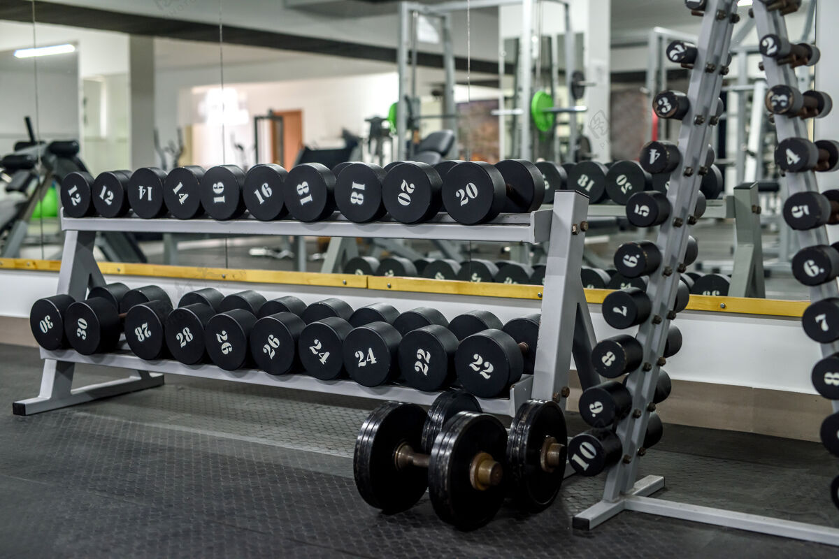 机器不同的体育器材在健身房里就像墙一样护理举重重