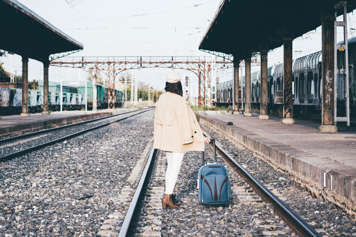 穿着得体一个穿着贝雷帽和米色夹克的女人在火车站等火车再见火车站女士