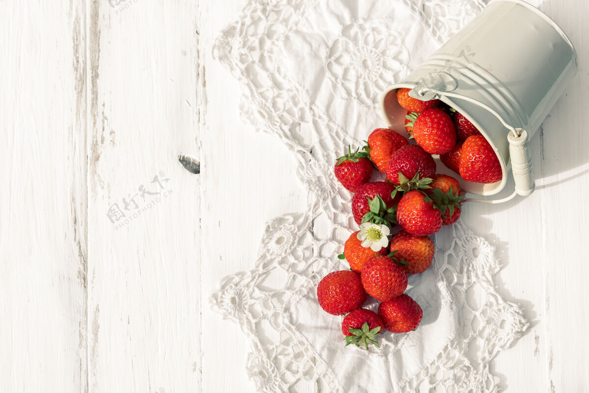 吃白色木质旧背景上的草莓 编织餐巾甜食浆果宏
