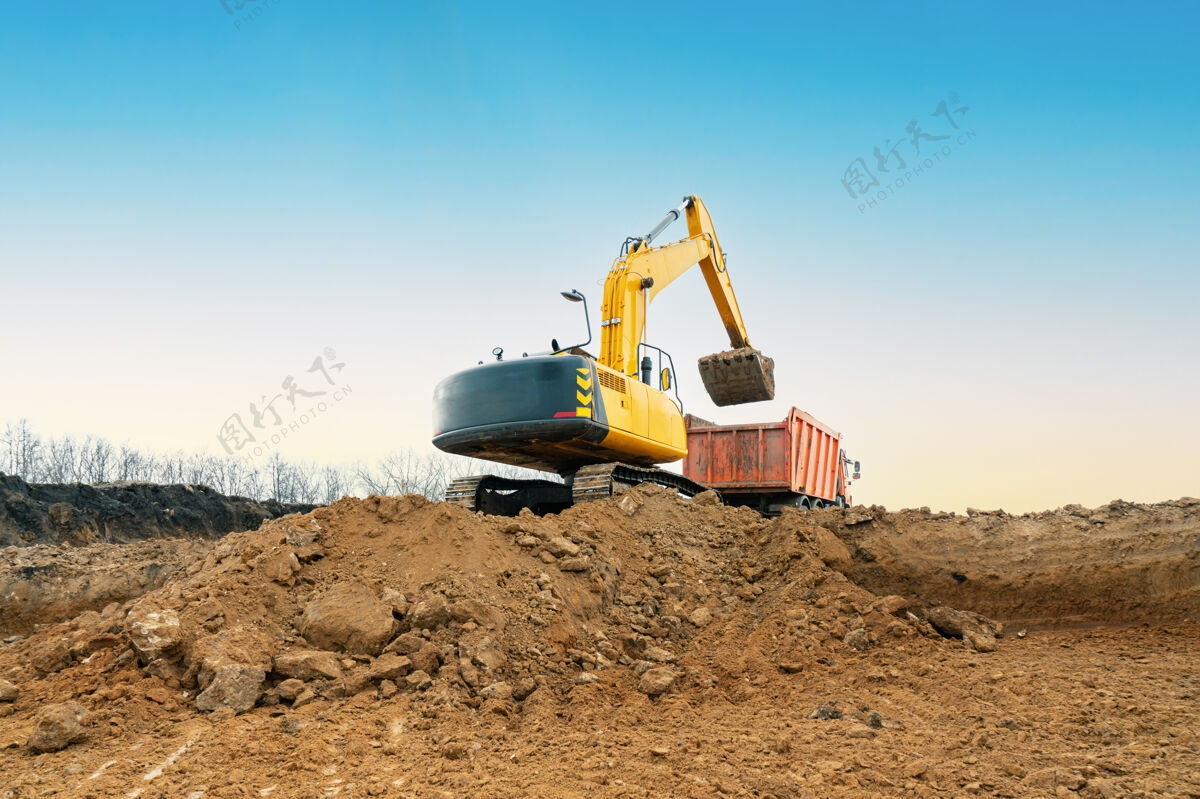 搬运机一台黄色的大型施工挖掘机在采石场的施工现场进行采石挖掘机铲子装载机