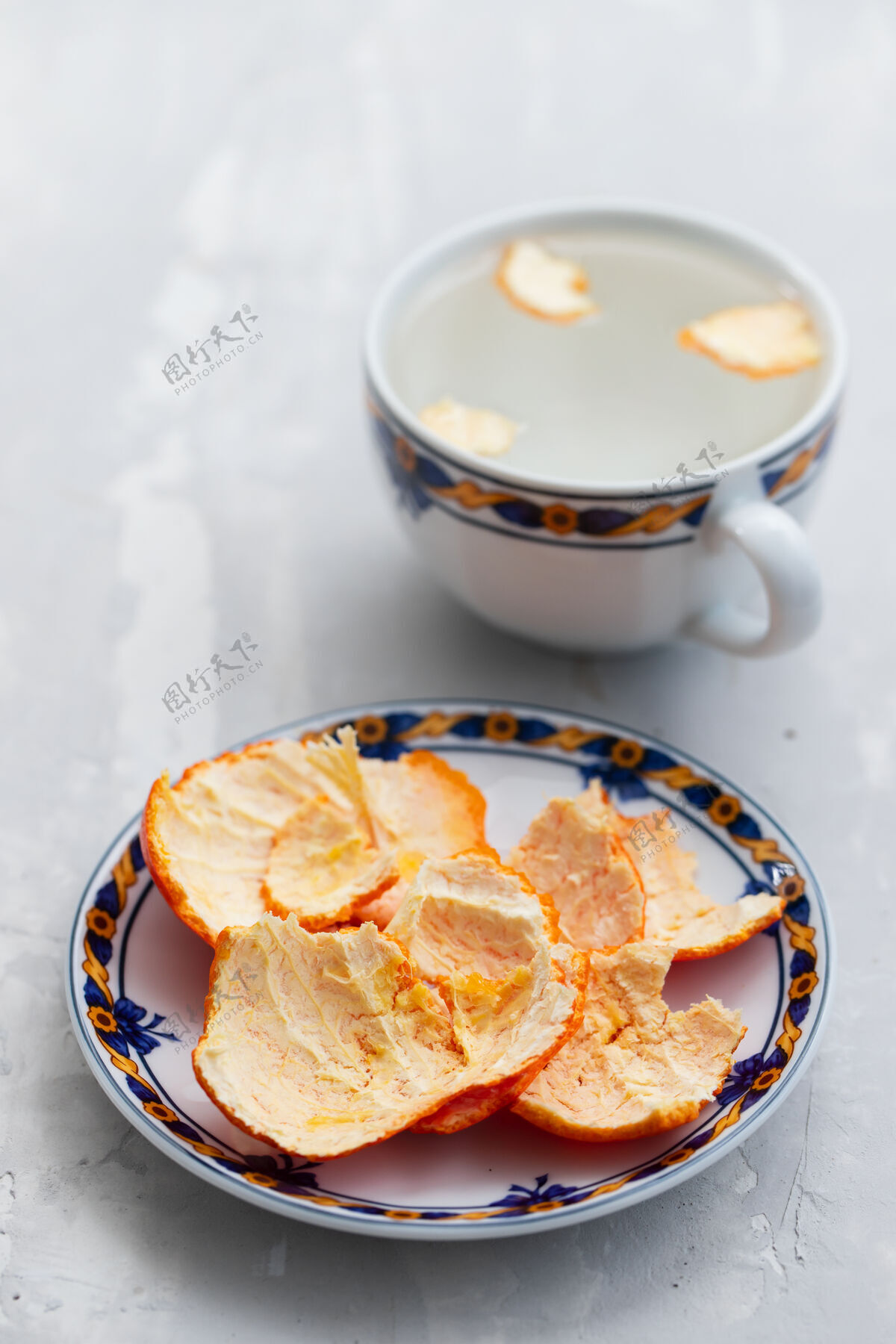 夏天把桔皮放在盘子里和热水杯里柑橘多汁物体