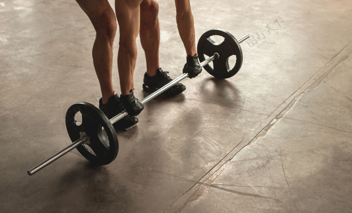 运动员高角度的匿名男运动员举重练习杠铃从地板上在健身房耐力活动激烈