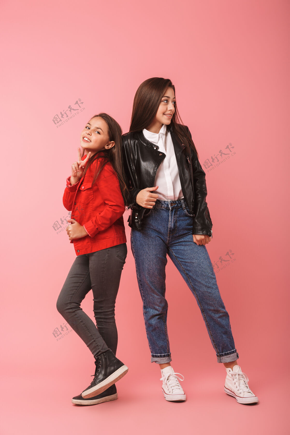 奥本完整的欧洲女孩在休闲站在一起 隔着红墙孤立的照片年轻完整姐妹