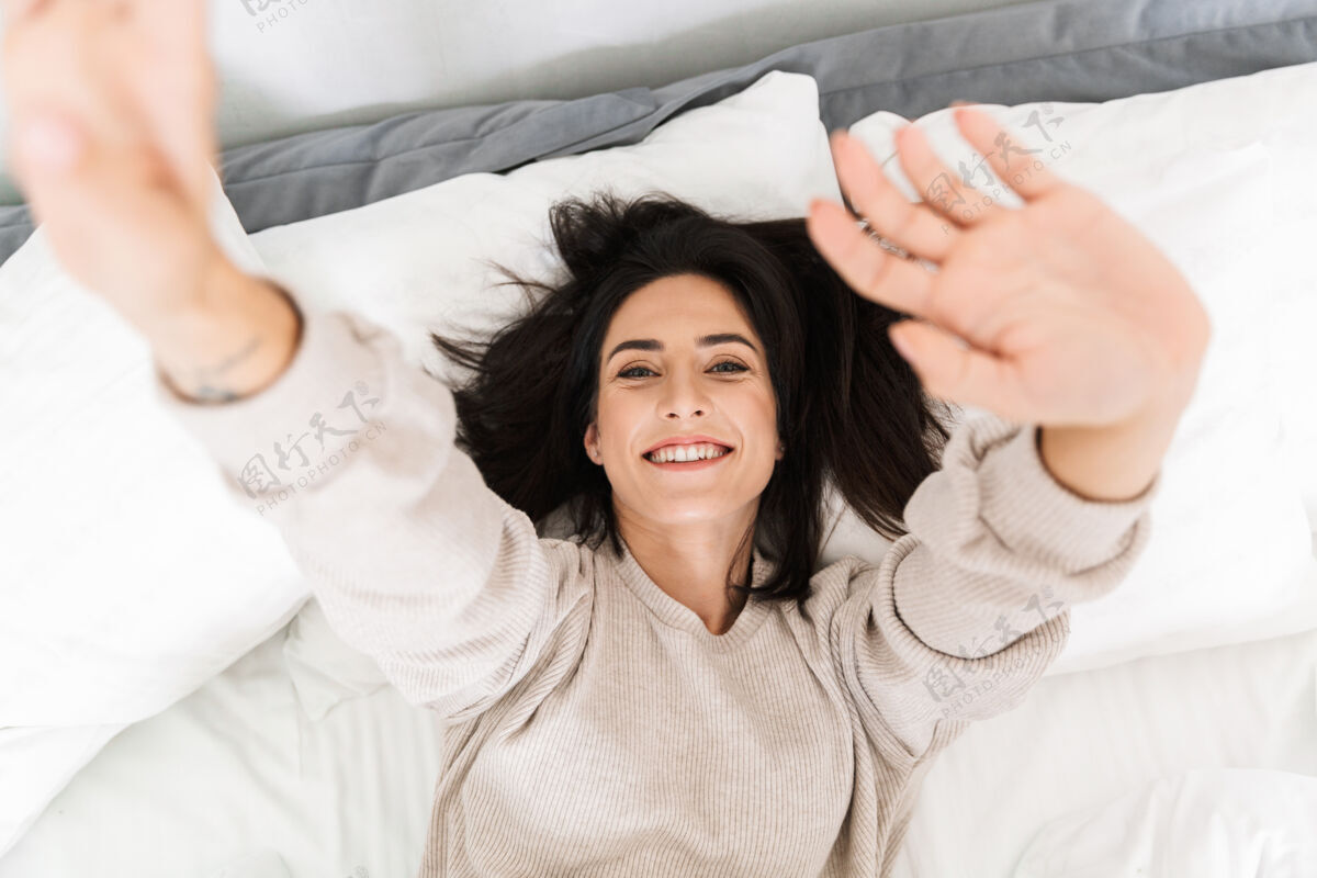 消遣上图是30多岁的快乐女人 在家躺在床上微笑公寓亚麻布肖像