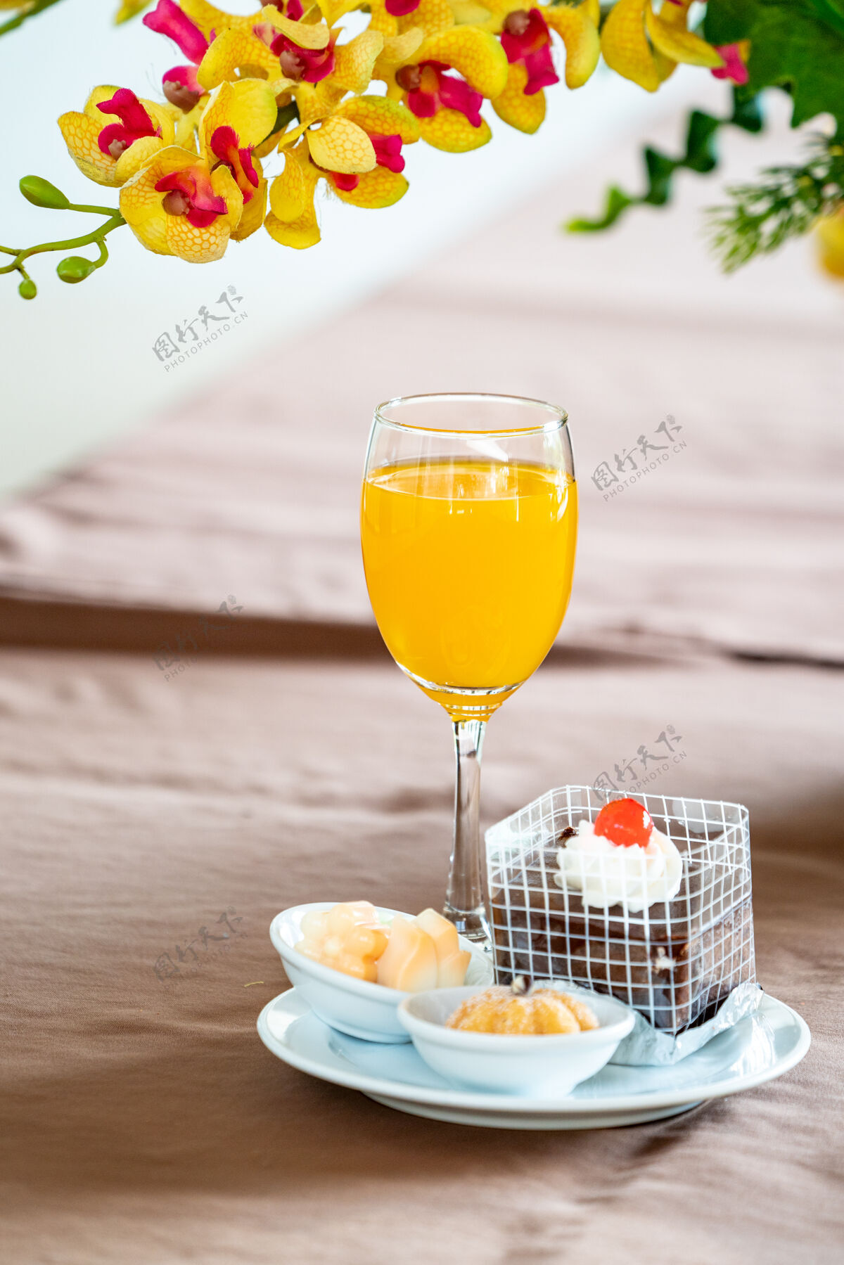 面包香槟杯里的橙汁 旁边有蛋糕和百吉饼霜冻杯子顶部