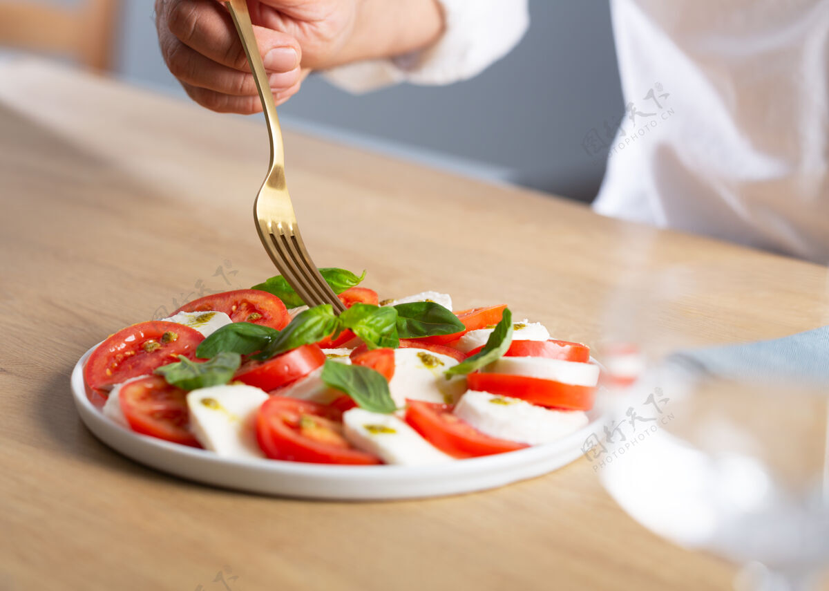 马苏里拉卡普列塞沙拉伙计吃著名的意大利沙拉 新鲜的西红柿 马苏里拉奶酪和罗勒奶酪新鲜营养