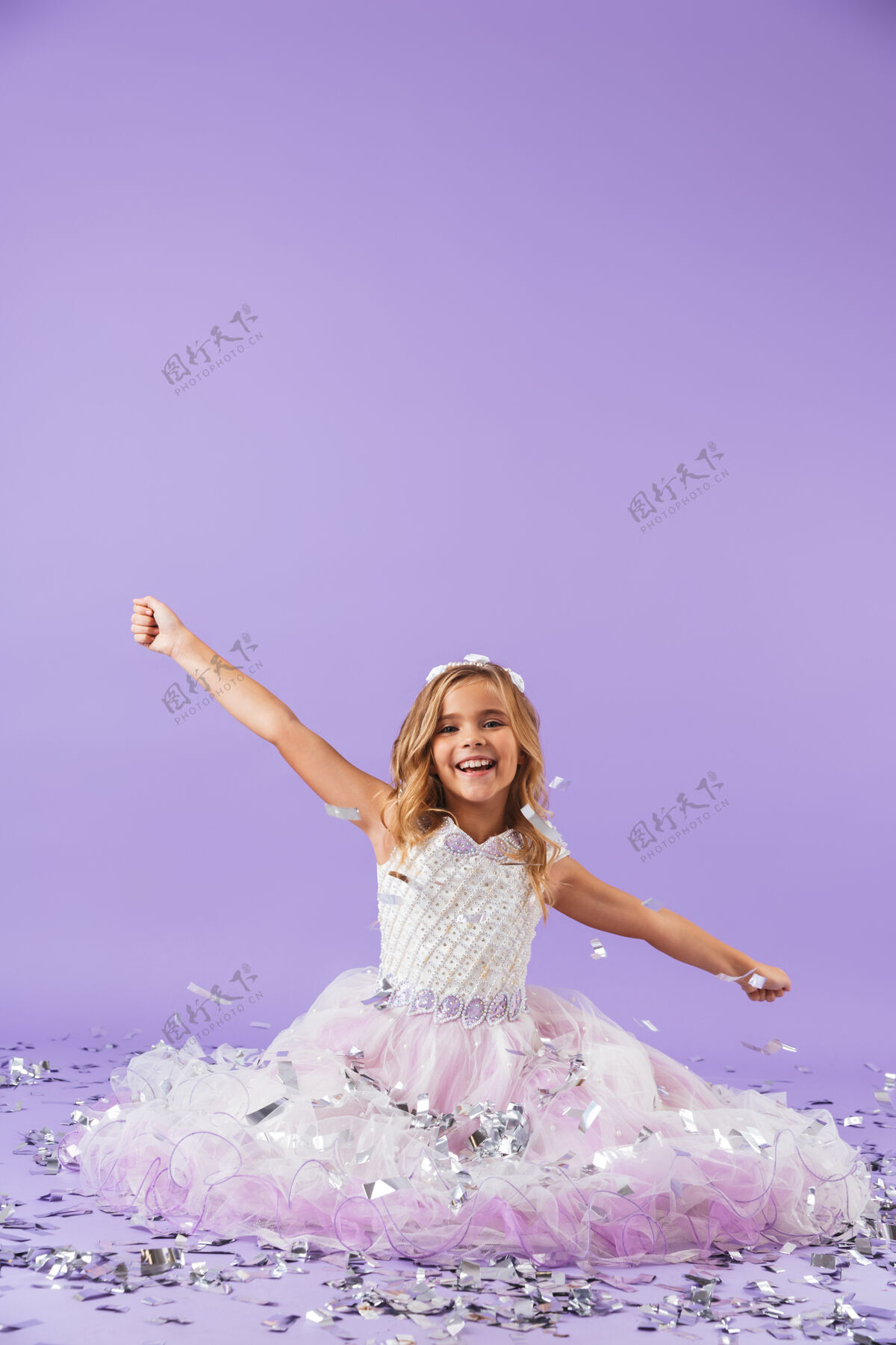 束穿着公主裙的漂亮小女孩孤零零地坐在紫罗兰色的墙上吸引力连衣裙美丽