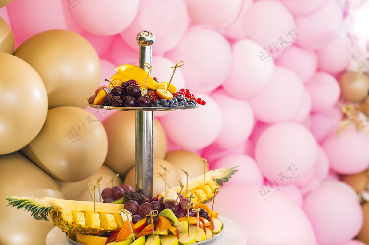 新用粉色和金色气球装饰以庆祝生日婚礼柔软聚焦糖果酒吧里有糖果和咖啡水果.美食给客人草莓菠萝樱桃蓝莓节日装饰礼物