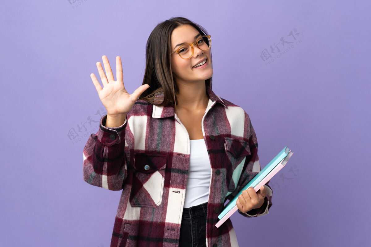 成功紫色的年轻女学生用手指数着五手指号码女