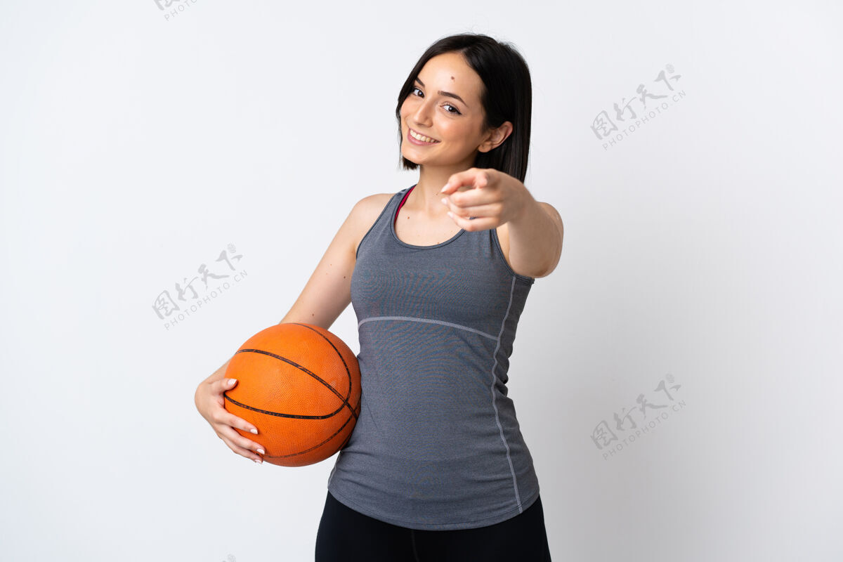 快乐打篮球的年轻女子孤零零地站在白色的墙上 脸上露出幸福的表情专业运动成人