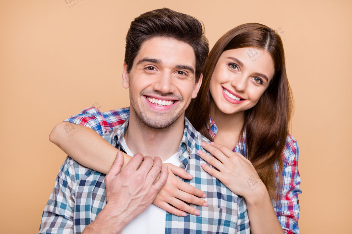 感情开朗积极可爱的两个白人夫妇的特写照片 他们微笑着 牙牙学语地相爱 深情地欣赏着米色粉彩背景下孤立的公司爱情积极快乐