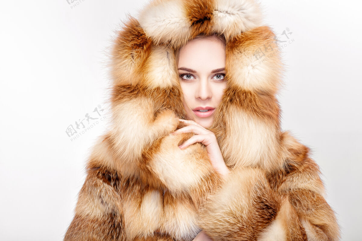 年轻身着豪华狐皮的年轻金发美女肖像大衣.冬天灰色背景时尚财富冬天狐狸
