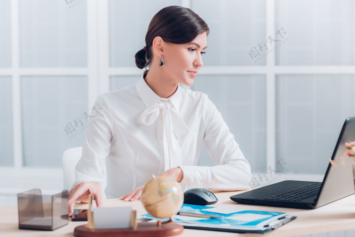 笔记本在办公室办公桌旁工作的疲惫迷人的女商人女性秘书自信