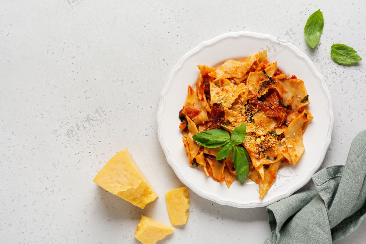 滋养意大利面加上经典的番茄酱 帕尔马干酪和罗勒 放在一张质朴的混凝土桌子上背景.传统意大利菜上菜上菜查看美味蔬菜饮食