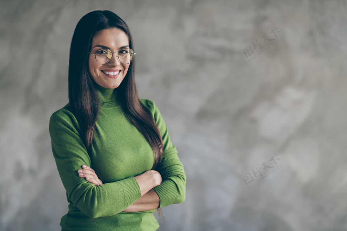 自信照片是一位快乐可爱的女友 双臂合拢在空旷的空间附近 在隔离的灰色墙壁混凝土背景上表达积极的情绪专业人士女商人眼镜
