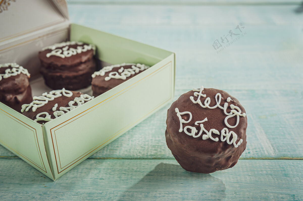 糖果蜂蜜曲奇巧克力覆盖着一个礼品盒写着复活节快乐-保德梅尔Alfajores食物桌子