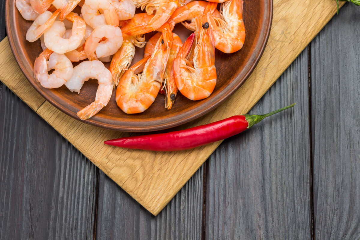开胃菜陶瓷虾盘子辣椒切菜板上的辣椒营养健康小吃