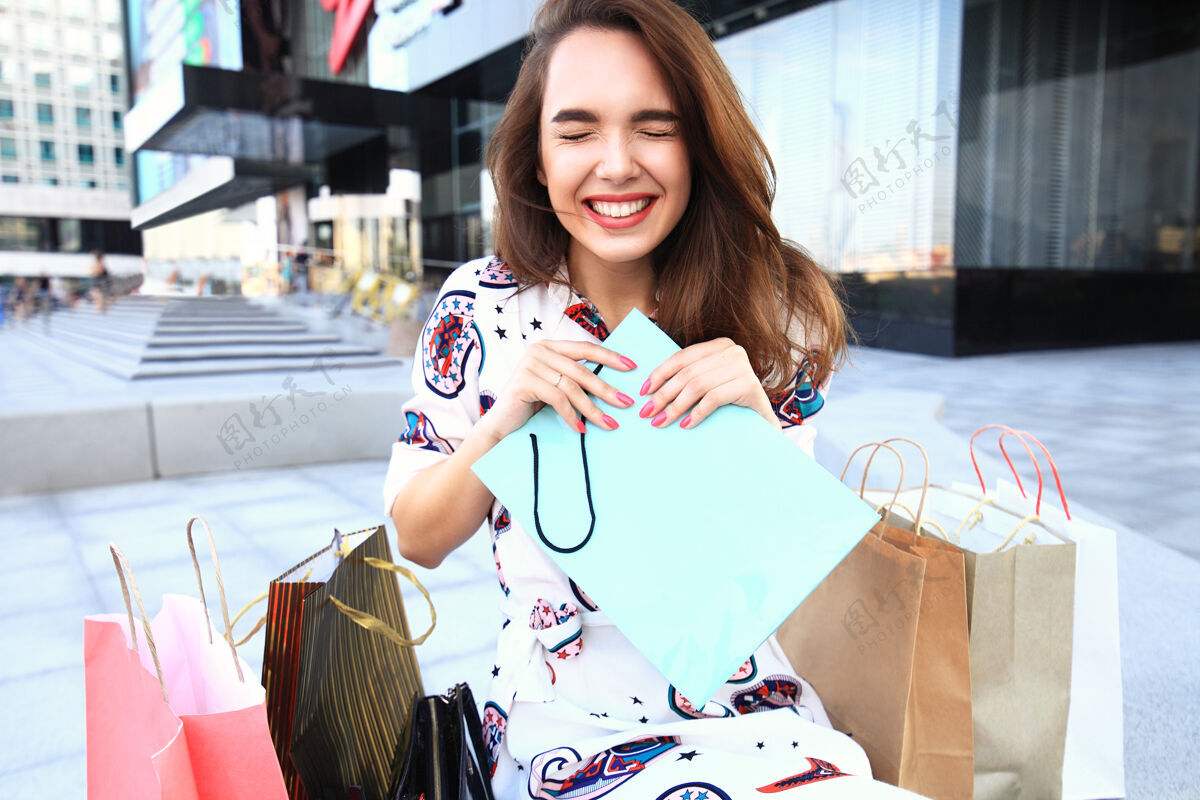 西班牙裔幸福的女人拿着购物袋 微笑着在商场购物亚洲奢侈品