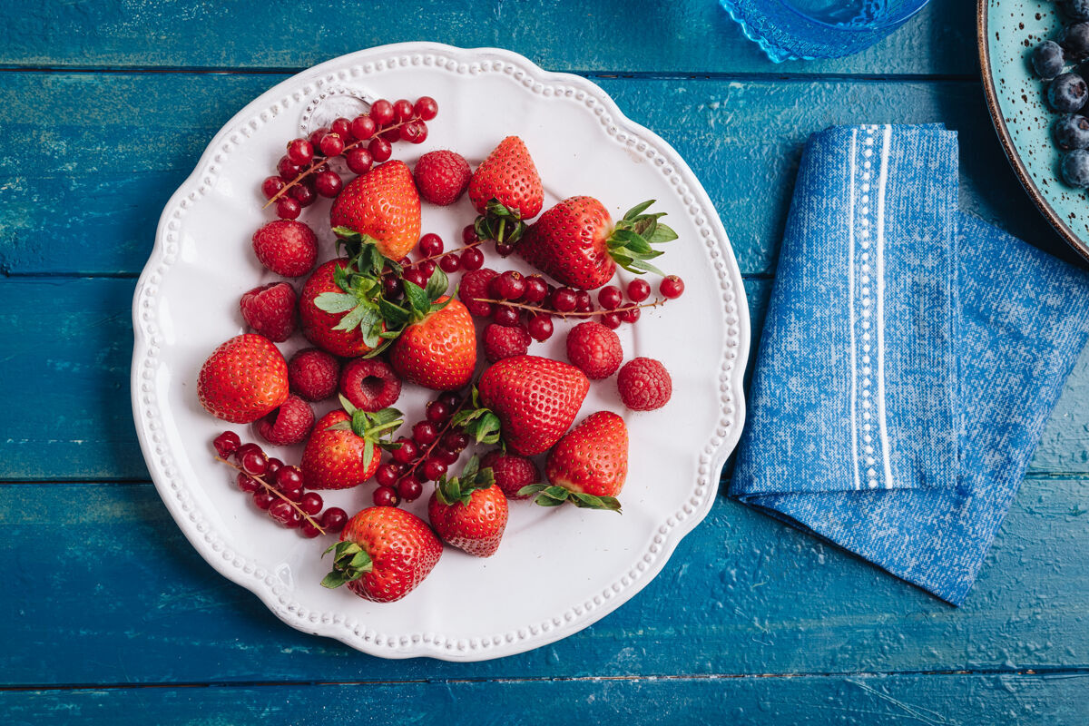 蔓越莓健康的早餐吃新鲜的红色浆果和水果草莓红醋栗混合