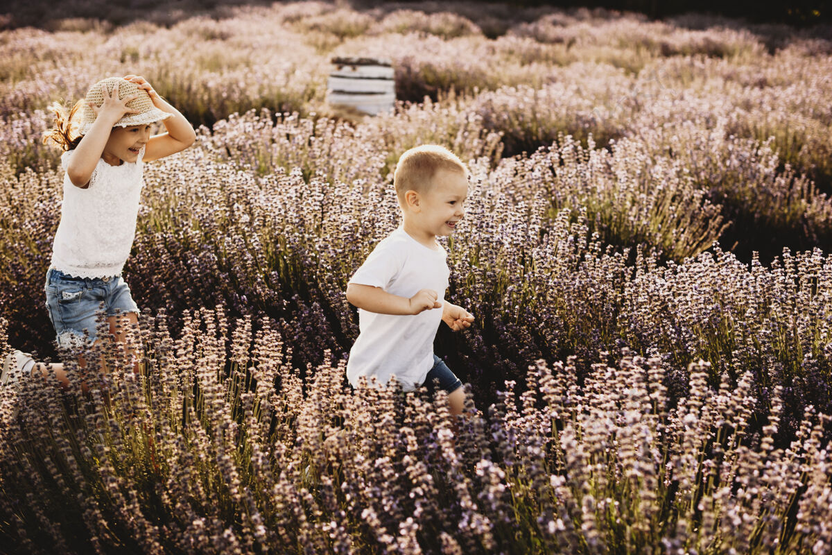 生态可爱的小男孩和他可爱的妹妹在花丛中欢笑童年朋友关系