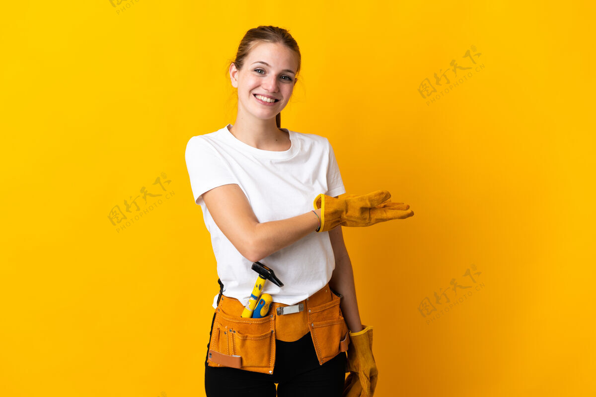 空一位年轻的电工女士被隔离在黄色的背景下 面带微笑地向她展示着自己的想法车间演示女孩