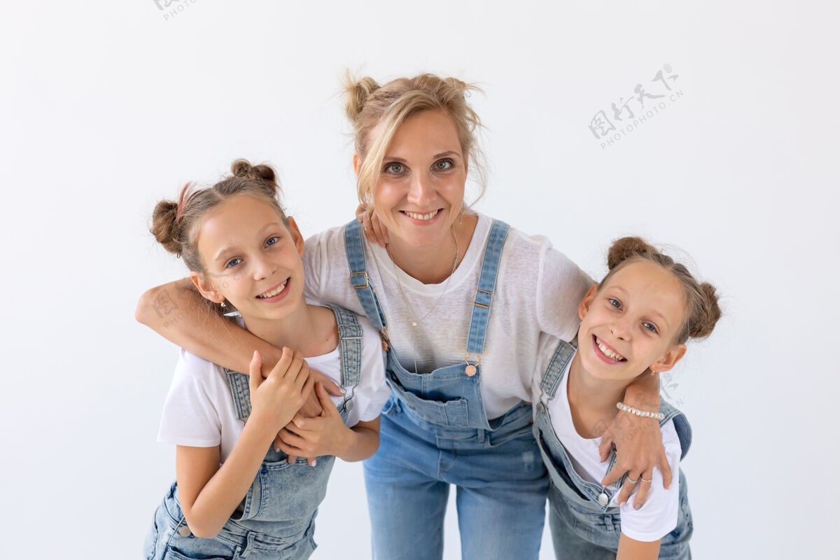 拥抱人 家庭和孩子的概念-双胞胎姐妹和他们的母亲在白色的表面亲子关系女士可爱