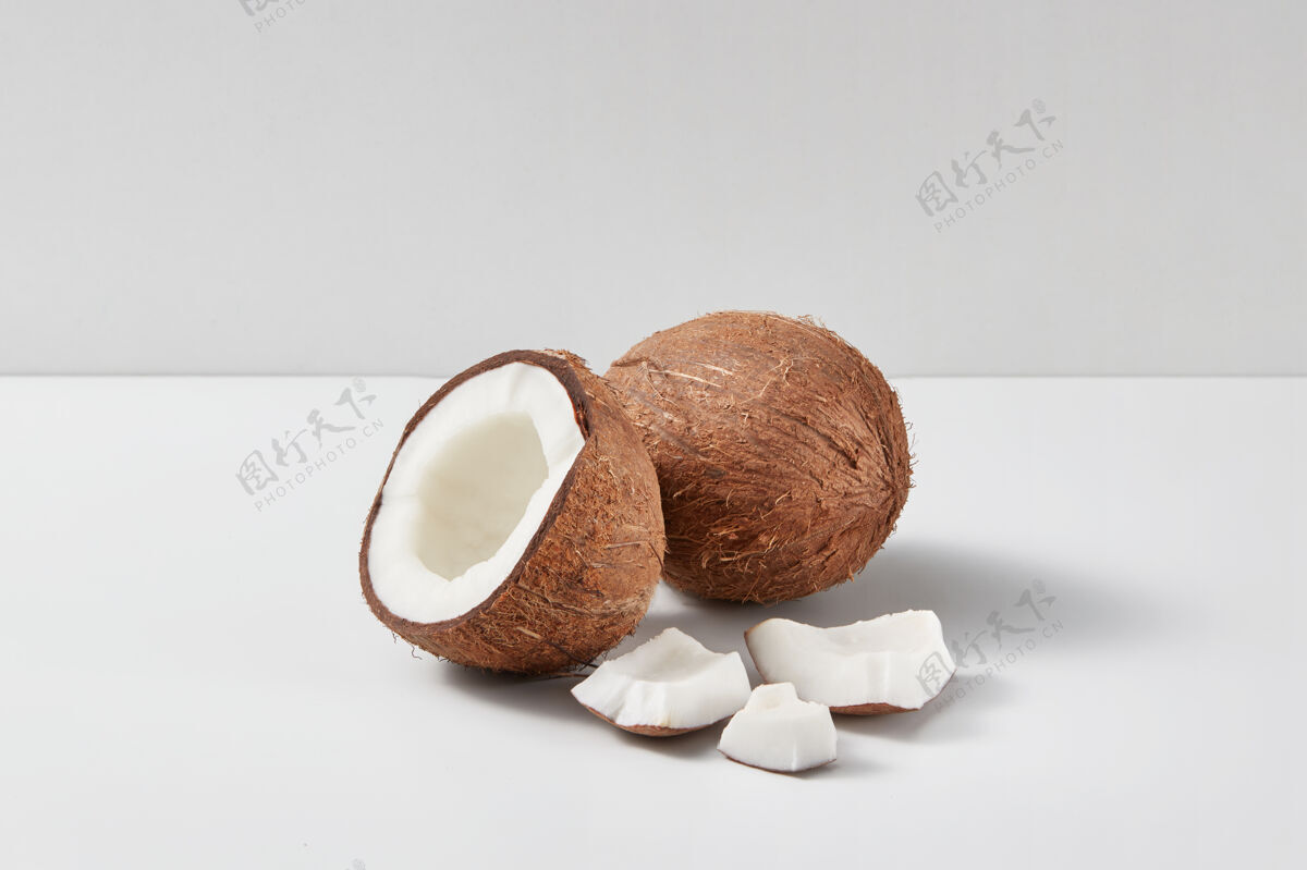生物由新鲜成熟的椰子果实制成的天然有机组合 半片和小块 浅灰色双色背景 复制品太空素食者概念半可食用食用