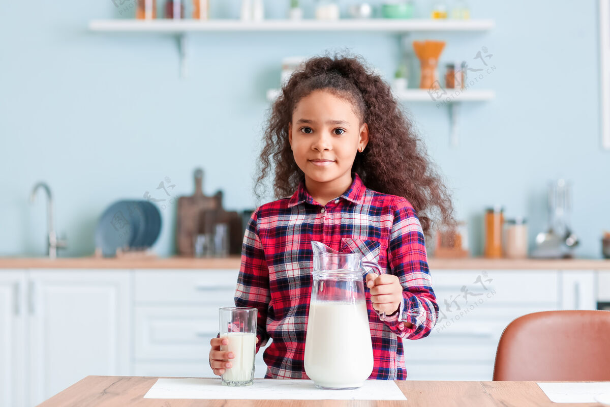 罐子厨房里有牛奶的非洲裔小女孩非洲维生素产品