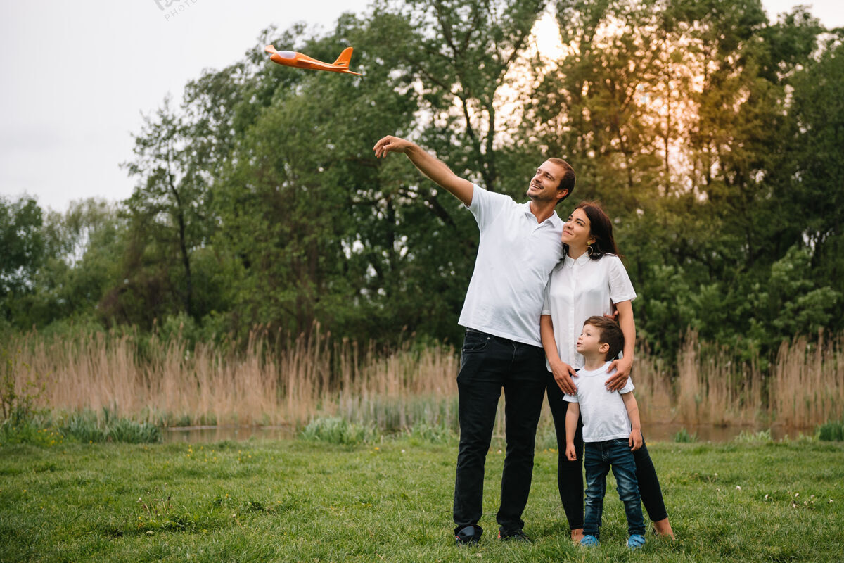 家庭爸爸 妈妈和儿子在公园里玩玩具飞机爱自然父母