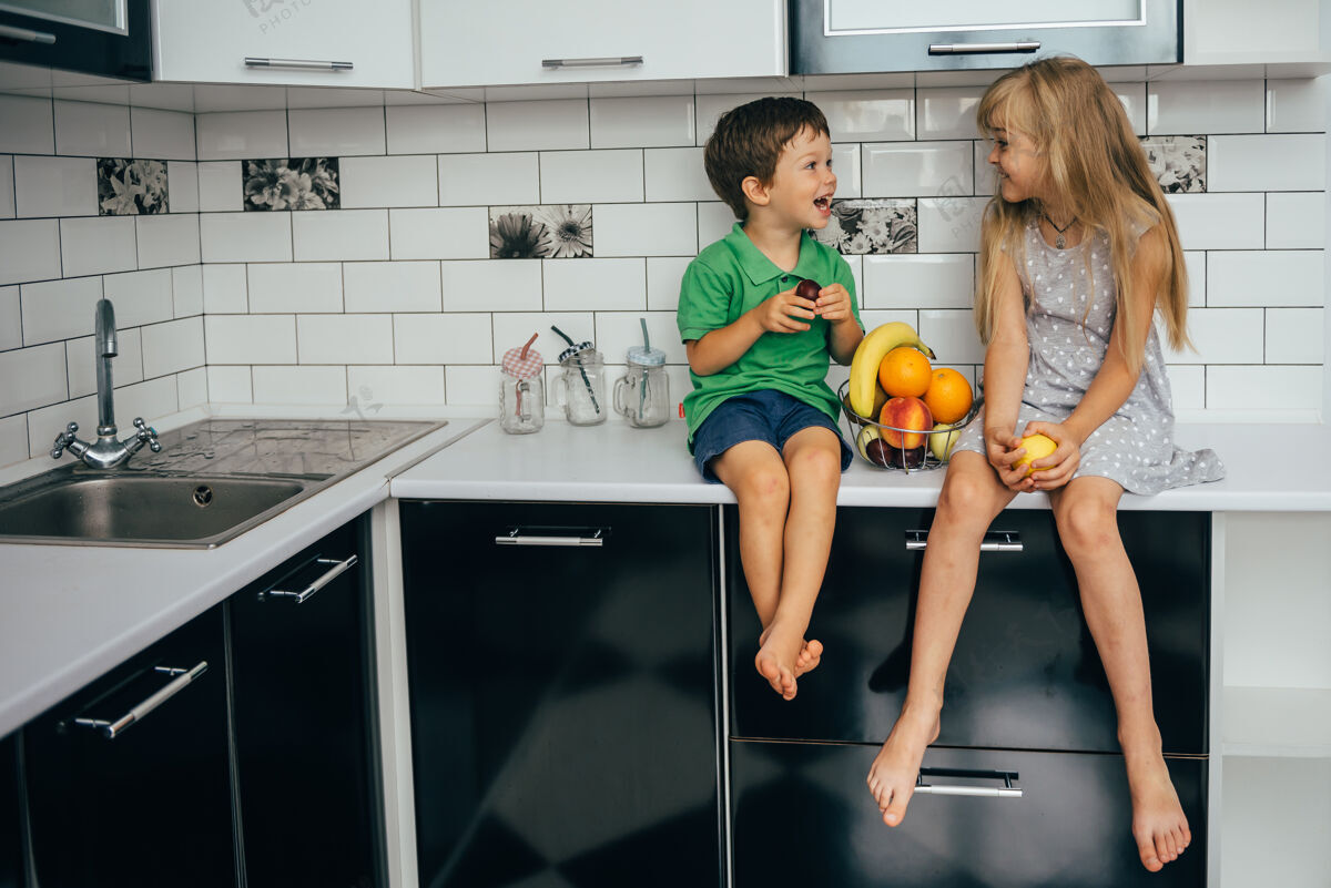 微笑健康的概念吃有趣孩子们在厨房里吃水果女孩孩子年轻