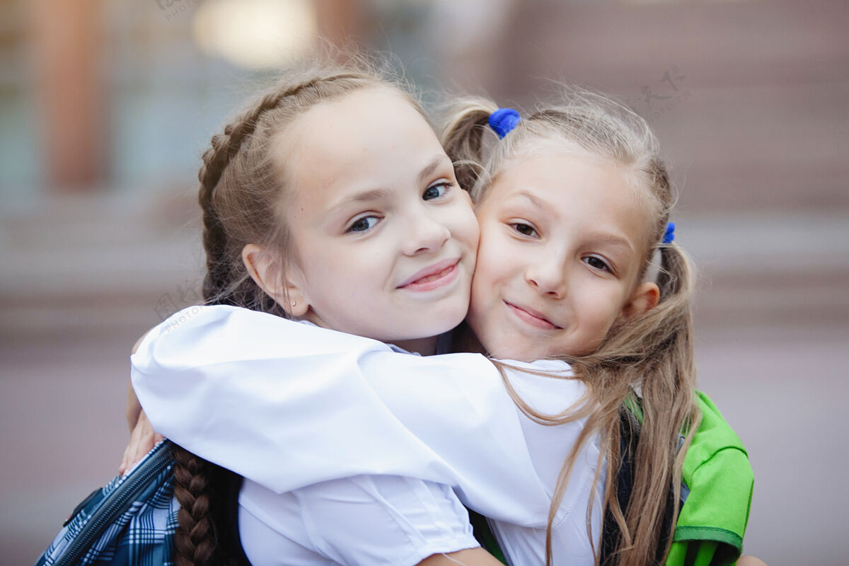 教育两个穿着制服 扎着马尾辫的十几岁的女学生拥抱着 欢喜着 微笑着裙子乐趣在一起
