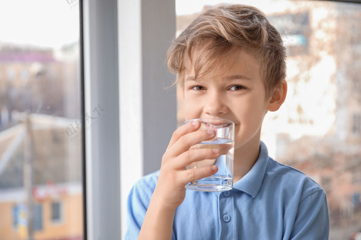 提神可爱的小男孩在窗户边喝水饮料水寒冷