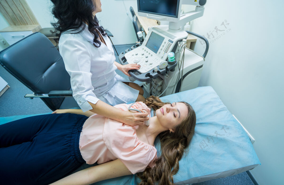 治疗医生用超声波扫描仪检查一个女人的甲状腺医学医生疾病