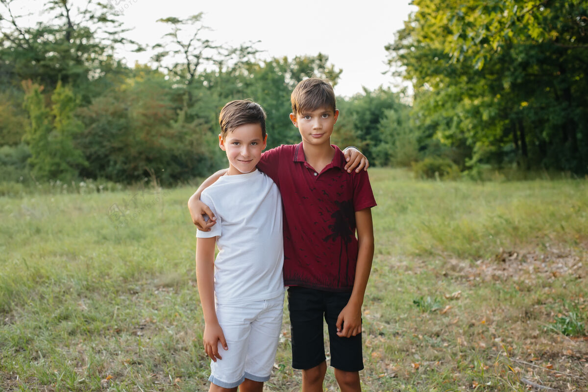 英俊两个快乐的小男孩站在公园里微笑着微笑童年小学生