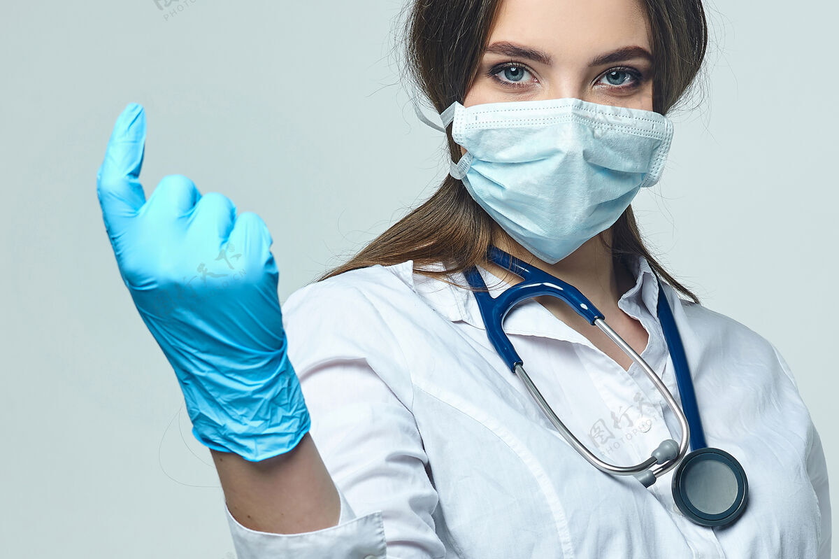 成人年轻的女医生用食指招手实习生病毒手套